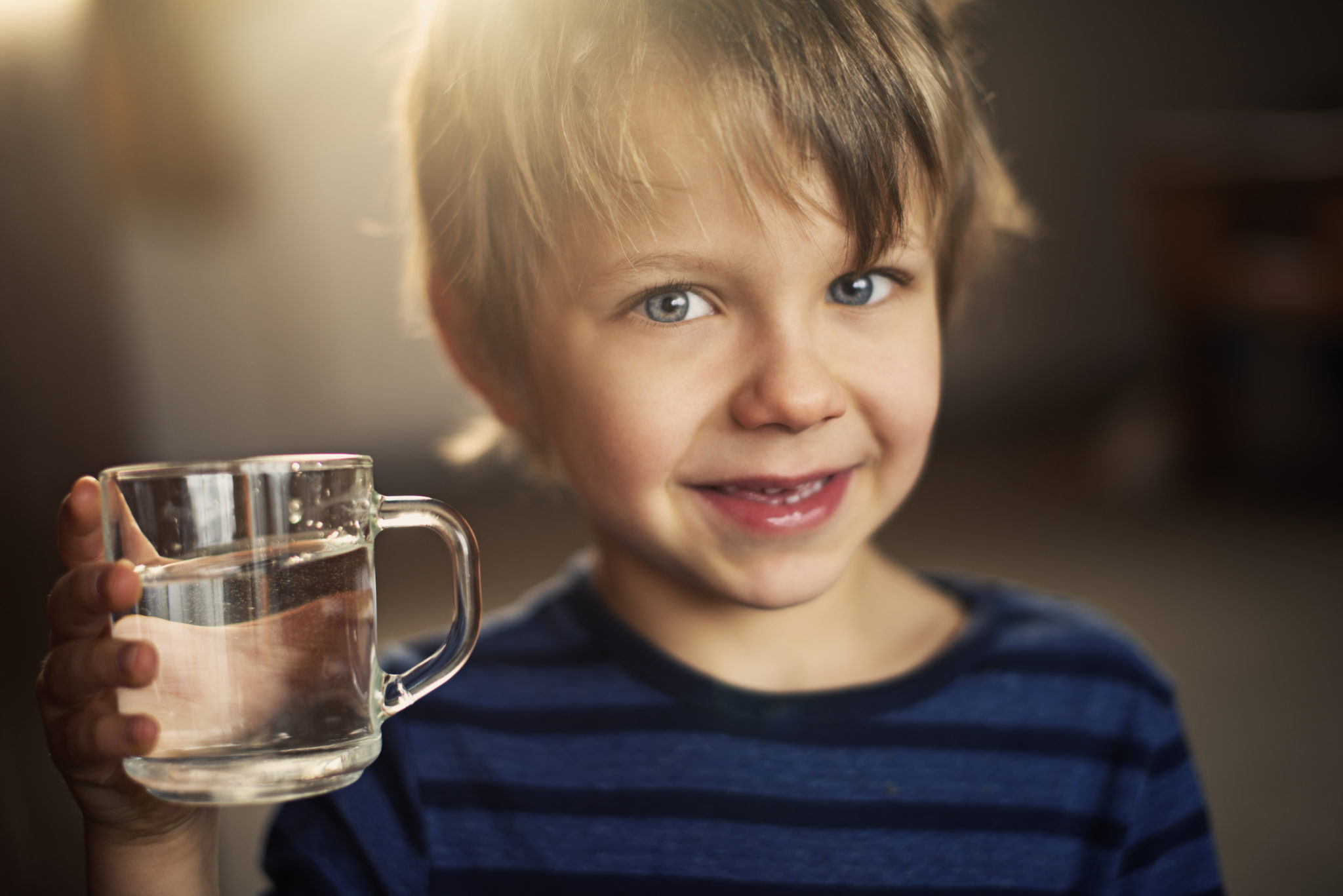 Little boy drinking glass of water. RO System Installation for the Valley