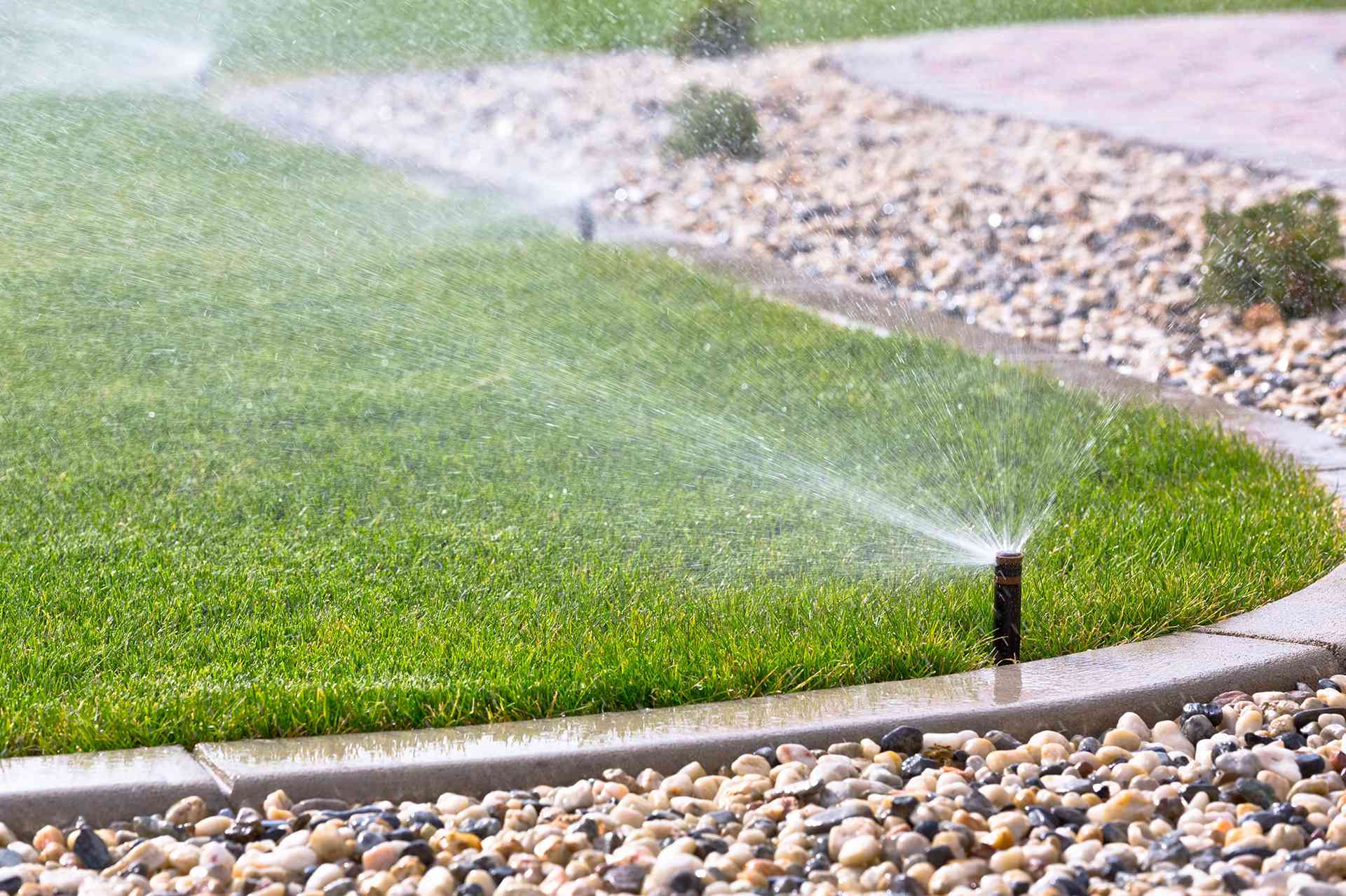 Irrigation Sprinkler System Watering Green Lawn in Phoenix, AZ<br />
